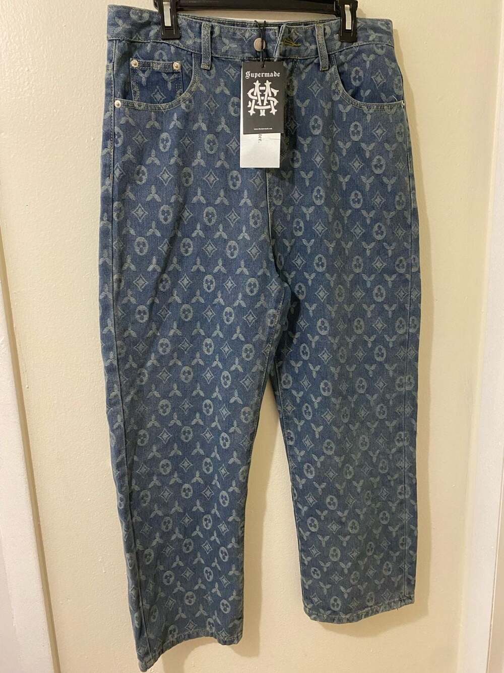 TheSupermade branded blue monogram patterned denim jeans.